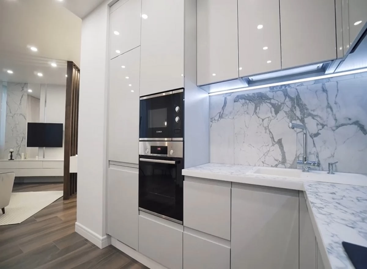 Белая кухня с крашеными фасадами и проходной ручкой. Фурнитура Blum и Hettich